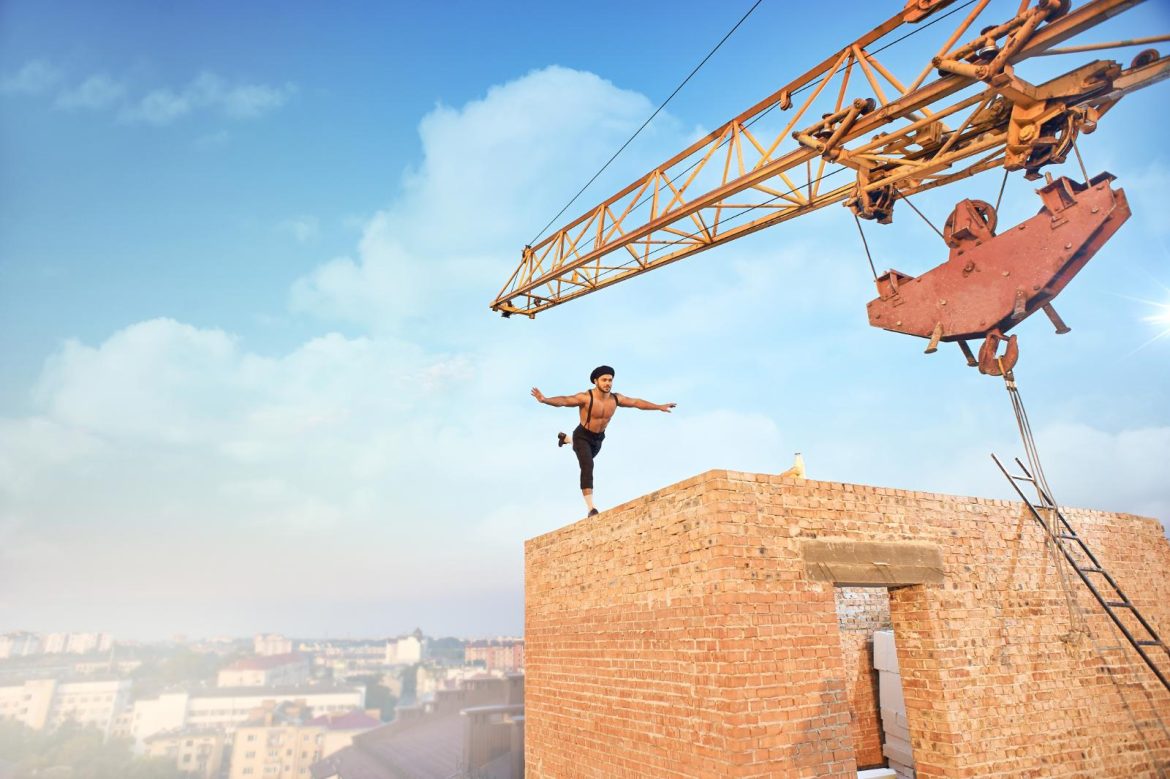 back-view-muscular-athletic-man-doing-exercise-high-brick-wall-un-finishing-building-high-big-iron-crane-cityscape-background (1)