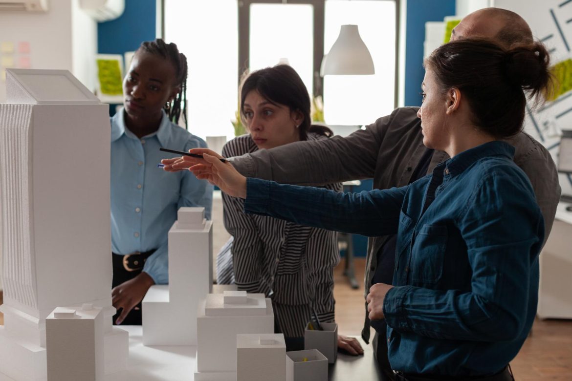 team-professional-architects-brainstorming-ideeas-pointing-real-estate-construction-model-architectural-office-mixed-group-engineers-working-residential-project-desk (1)